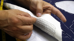 Close-up of hand pick-stitching on a custom garment lapel